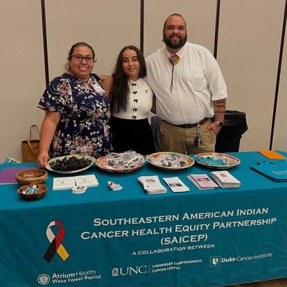 Three people standing behind a table