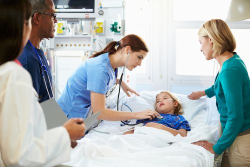 Menina na cama do hospital cercada pela mãe e funcionários do hospital