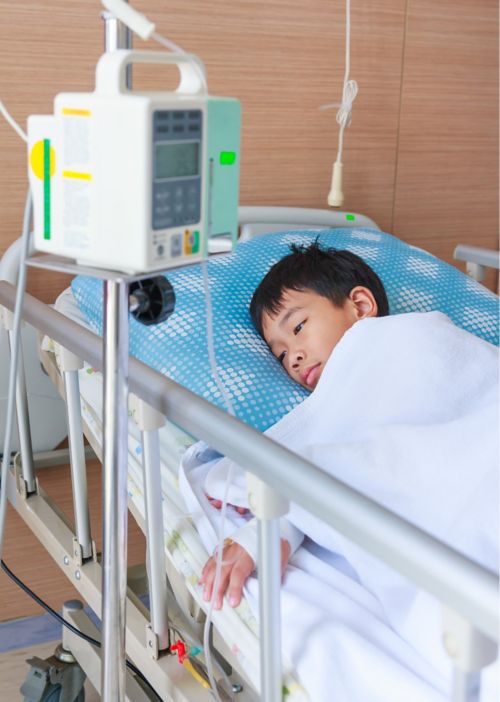 Little boy in hospital bed with monitor