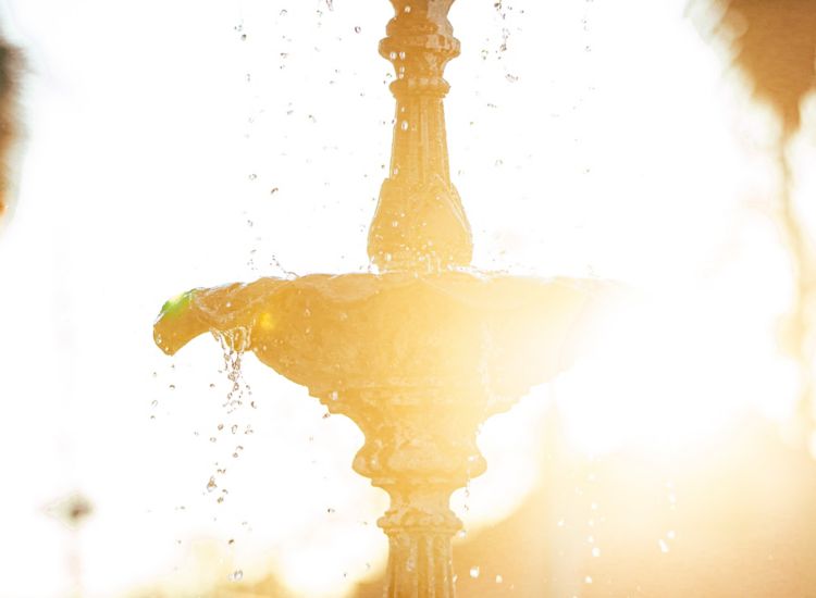 Fountain in foreground with sun in background