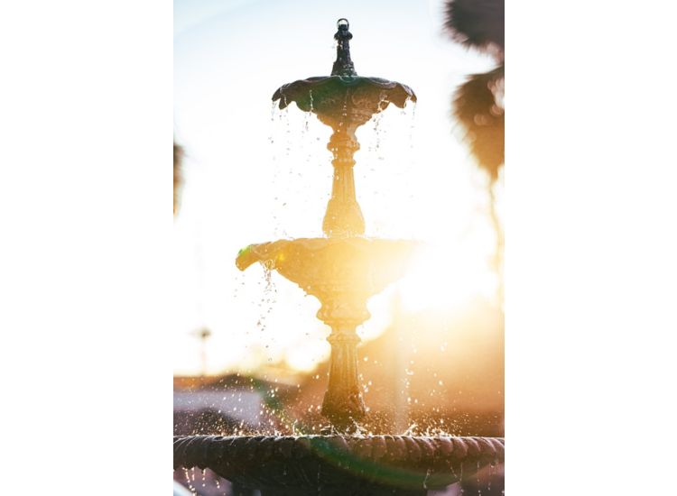 Fountain in foreground with sun in background