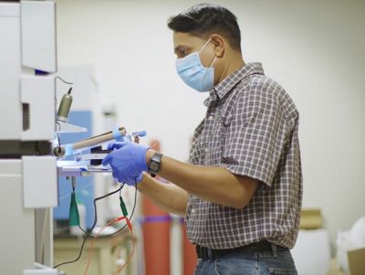 photo of man working with complex lab equipment