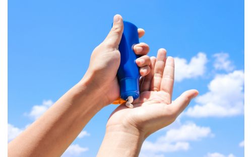 Person using sunscreen lotion