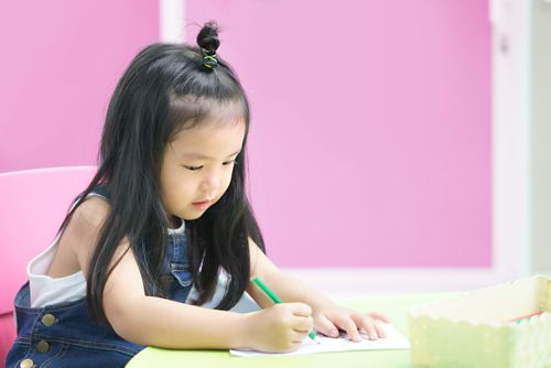 A young student writing on a sheet of paper.