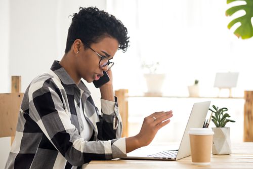 Person on the phone while looking at computer