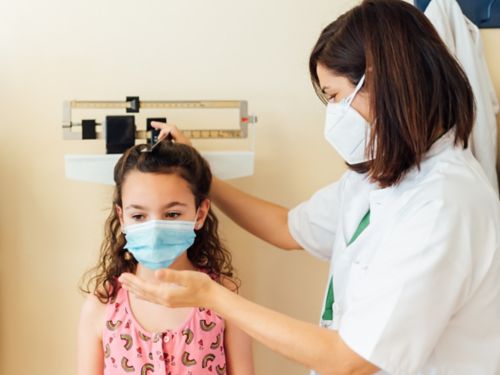 child getting height measured by a clinician 