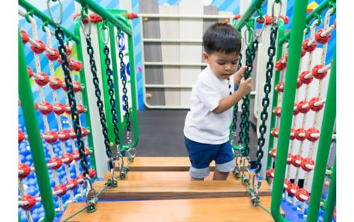 Toddler playing in an indoor jungle gym