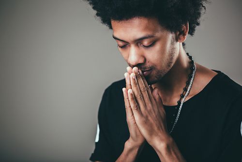 Man meditating with hands in prayer