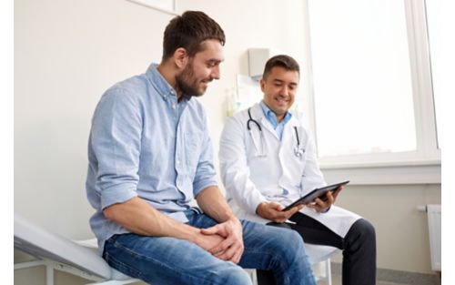 Male teen patient sitting with doctor in medical setting