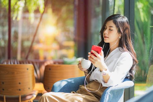 Someone listening to music in headphones from a mobile phone