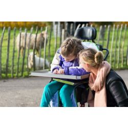 Social worker helps girl in wheelchair.