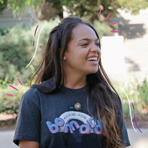Somer smiling and wearing a t-shirt that says Bonnaroo
