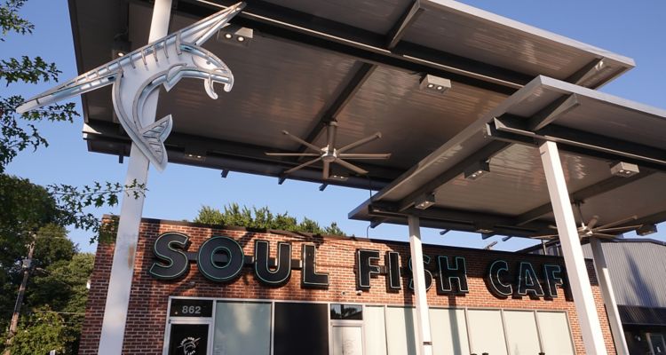 Exterior of Soul Fish Cafe in Memphis featuring modern sculpture of fish.