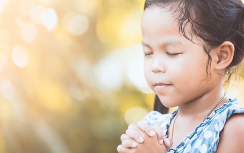 Child praying with eyes closed