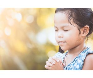 Female child praying with eyes closed