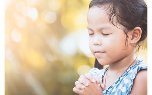 Female child praying with eyes closed