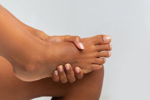 A woman holding her bare foot 