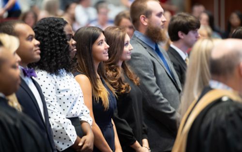 Graduate school students standing at event