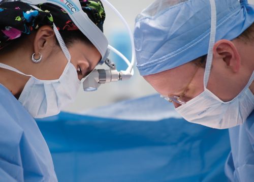 Deux chirurgiens oncologues spécialistes du cancer pédiatrique pendant une chirurgie