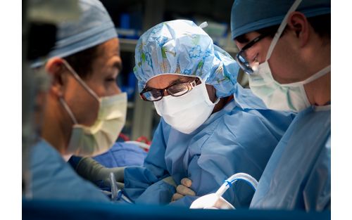 team of surgeons in operating room wearing scrubs