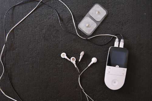 Closeup of a TENS unit on a black background.