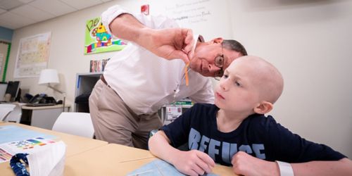 Man showing student piece of paper