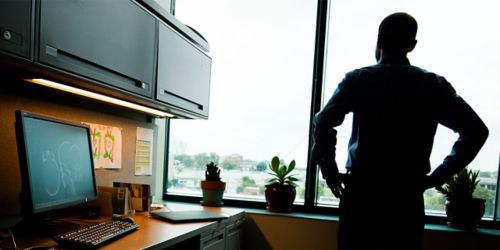  Image of man looking out window with his back to the camera