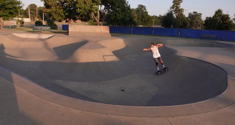 Tobey Skate Park with a skateboarder at golden hour sunset in Memphis.