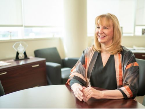 Photo of Elaine Tuomanen sitting at a table.