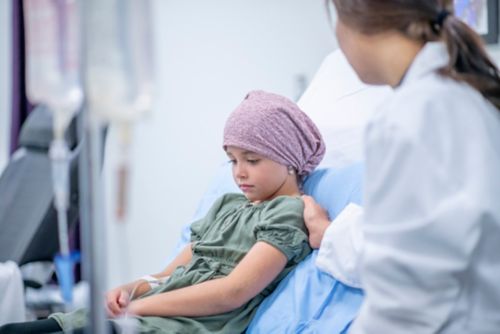 Young female cancer patient receiving medical treatment