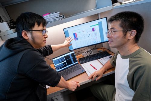 Photo of two men working at a computer