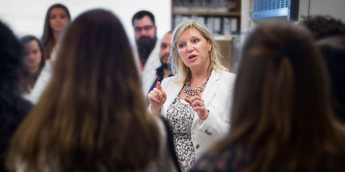 Photo of Stacey Schultz-Cherry, PhD, talking to group of students