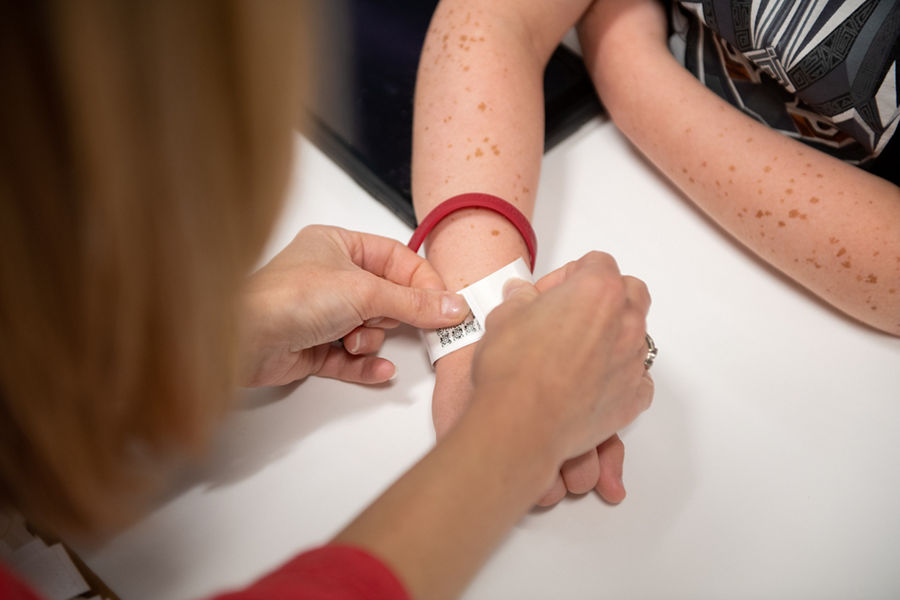 Putting an armband on a patient's wrist