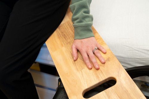 Haga que su hijo(a) ponga una mano en la tabla deslizante para equilibrarse.