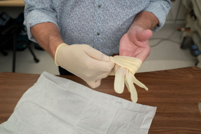 Putting on second sterile glove with palm face up