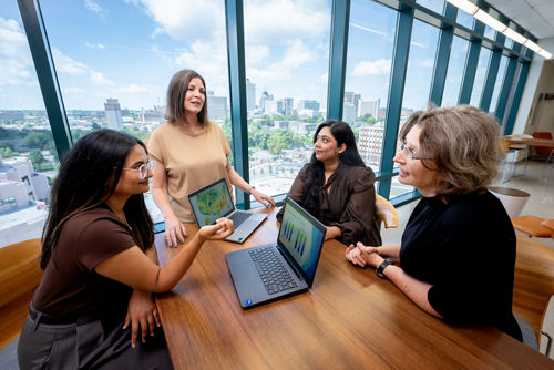 Four women at a table in front of a window with a view of downtown Memphis