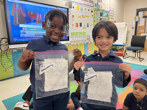 two boys holding bags with seeds