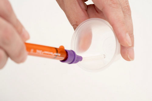 Se puede usar un accesorio DoseMate con la jeringa ENFit para extraer el medicamento de un vaso dosificador.