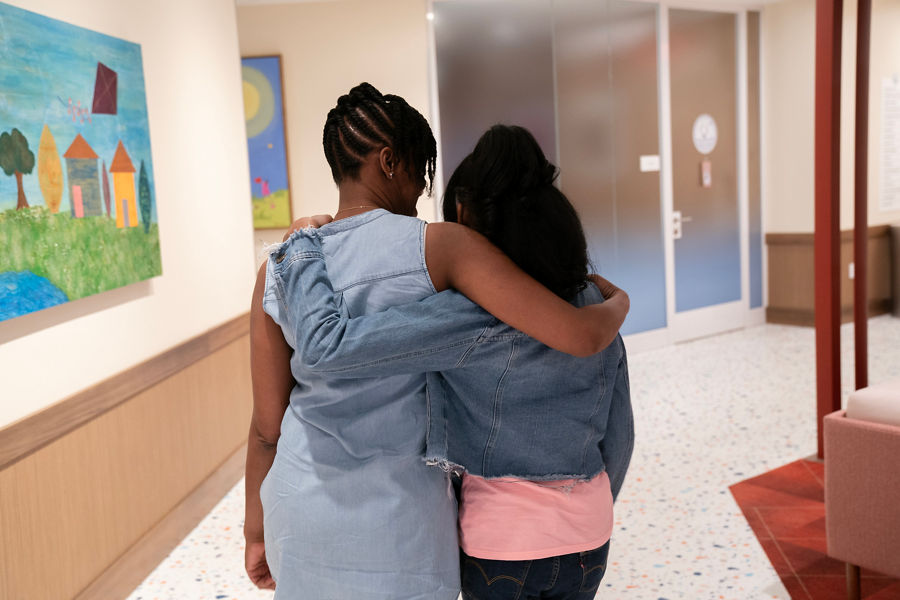 A mother and daughter walk through halls of Family Commons at St. Jude Children's Research Hospital. 