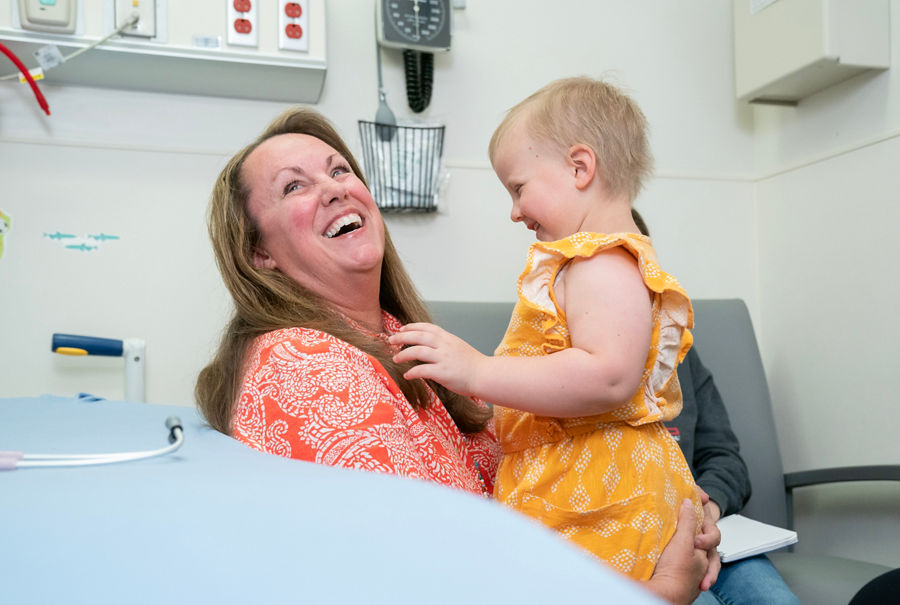 Woman smiling while holding toddler