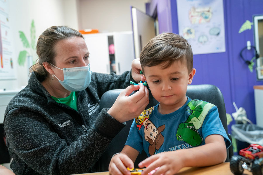 Profesional médico examinando el oído de un niño