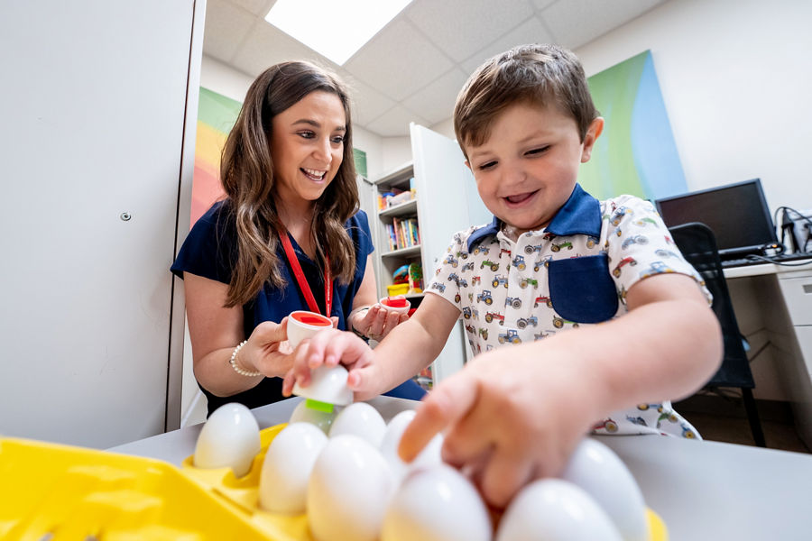 A speech therapist playing with child cancer patient