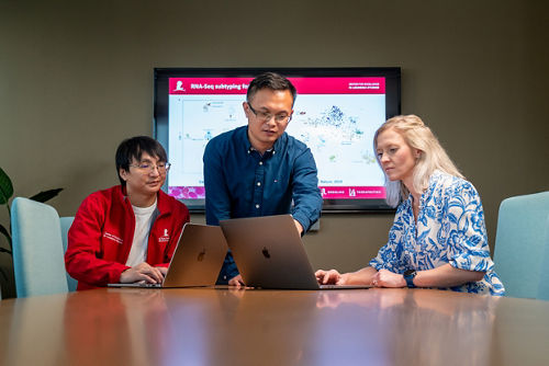three people in front of a computer screen
