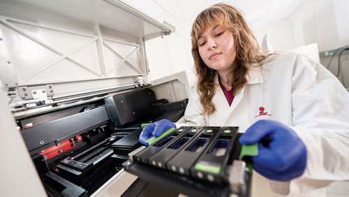 Scientist's hand working with a laboratory machine.