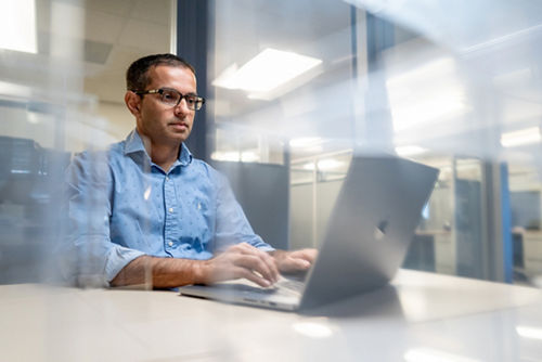 Yadav Sapkota, PhD, sitting at computer in office