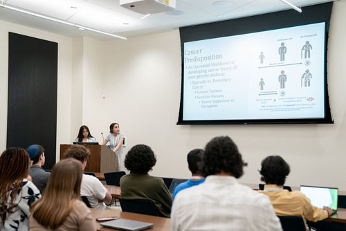 Two high school girls presenting research to a group