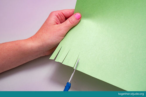 Hacer pequeños cortes en cartulina con tijeras