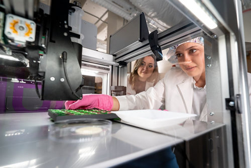 Two women working with 3d printer