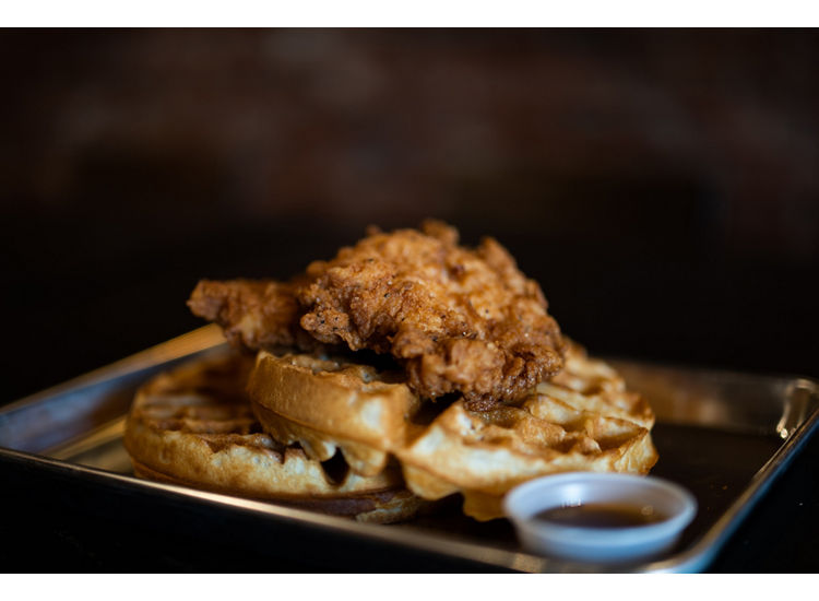 Stock photo of waffles and chicken on a metal tray