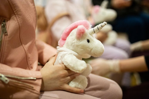 Criança com um unicórnio de pelúcia